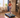 A woman in workout gear runs on a treadmill in a cozy, well-lit living room with wooden floors and modern decor.