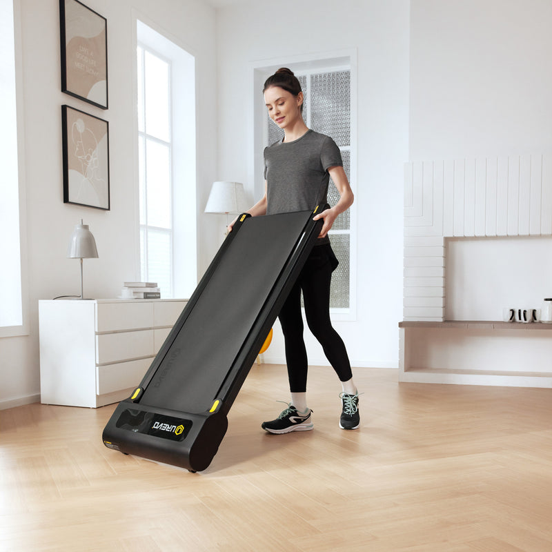 Enjoy light exercise at home! A woman handles the slim UREVO SpaceWalk 3S Smart Walking Pad in her bright living room