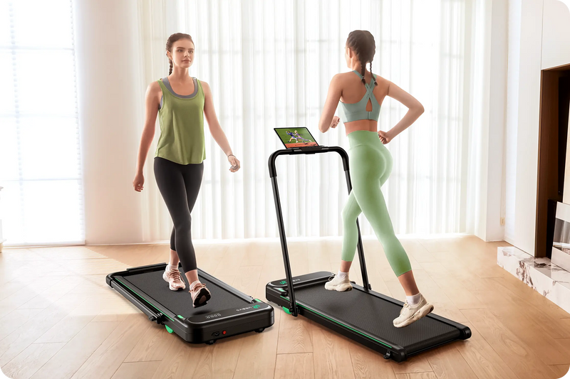 In a home gym, a white woman is walking on a walking pad on the left, and another white woman is running on a walking pad on the right.