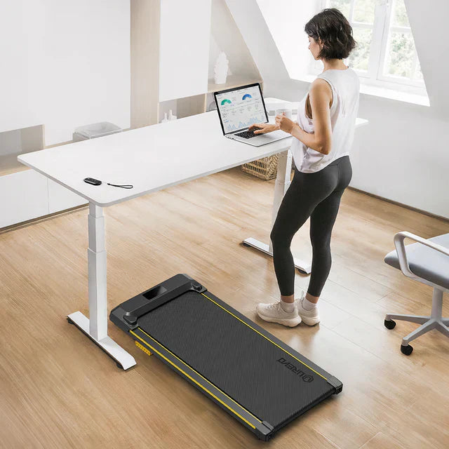 A Woman working and a UREVO Portable Treadmill beside