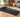 Black walking pad treadmill in a modern living room.
