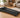 Black walking pad treadmill in a modern living room.