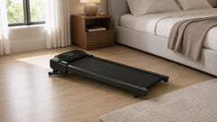 Compact walking pad with digital display in a modern bedroom.