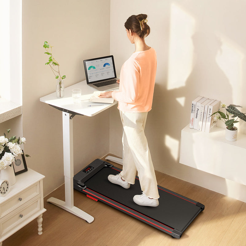 Woman works at standing desk while walking on UREVO SpaceWalk E1 Walking Pad