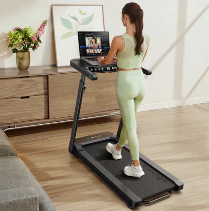 A woman in light green workout attire using a treadmill with a tablet stand in a modern living room.