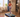 A woman in workout gear runs on a treadmill in a cozy, well-lit living room with wooden floors and modern decor.