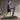  A man in a blue shirt and black shorts is walking on a treadmill.