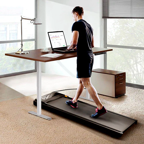 Man walking with a UREVO under-desk treadmill