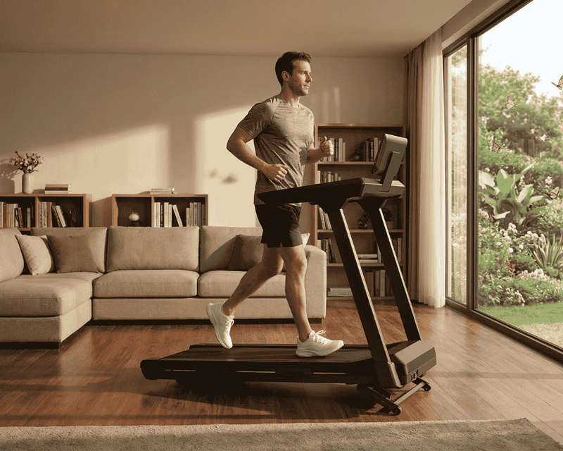 A white man is working out on a treadmill at home