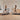 Two women are exercising on treadmills in a modern, minimalist room with wooden floors