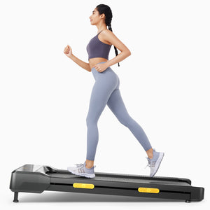 Woman using UREVO SpaceWalk 2S Lite Walking Pad, a compact walking treadmill for home workouts. Gray leggings and sports bra.