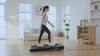 UREVO Spacewalk 2 Treadmill in a modern living room, with a woman walking on it.